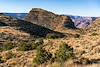 The peak of Comanche point rises above the skyline with no trail in sight and the colors of the Grand Canyon in the distance.