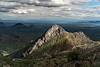 A sunlit rocky ridgeline is surrounded by shadows in the Waterman Mountains.